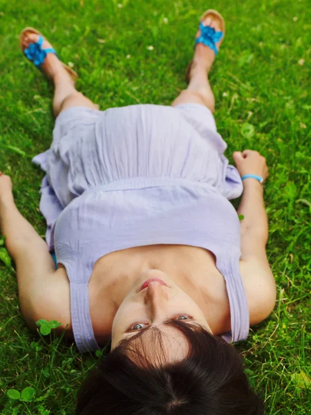 Беременная женщина лежит на траве . — стоковое фото