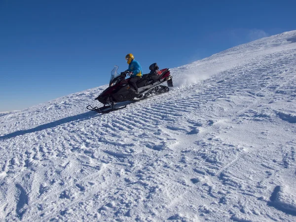 El hombre montando en la moto de nieve . — Foto de Stock