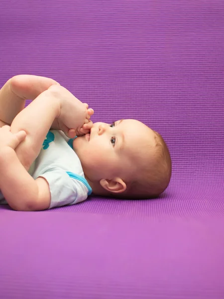 Bebé sobre un fondo morado . —  Fotos de Stock