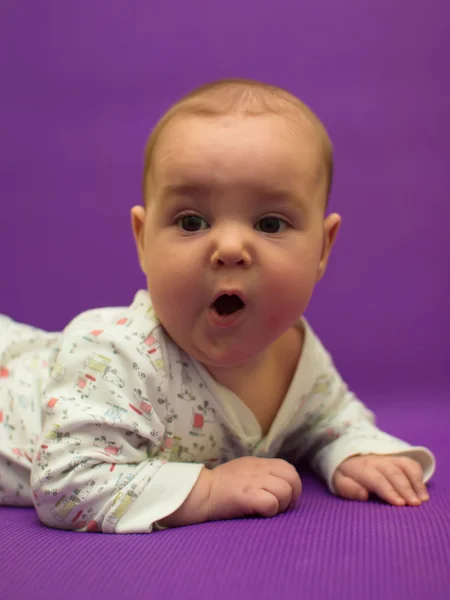 Bebé sobre un fondo morado . —  Fotos de Stock