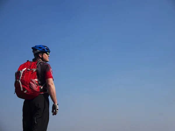 Un homme avec un casque et un sac à dos sur une montagne . — Photo