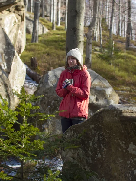 The girl with the mug stands near the stones. — Stock Photo, Image