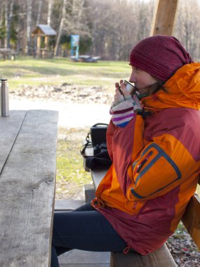 Kız bir tablo ve bir fincandan içmek oturur.