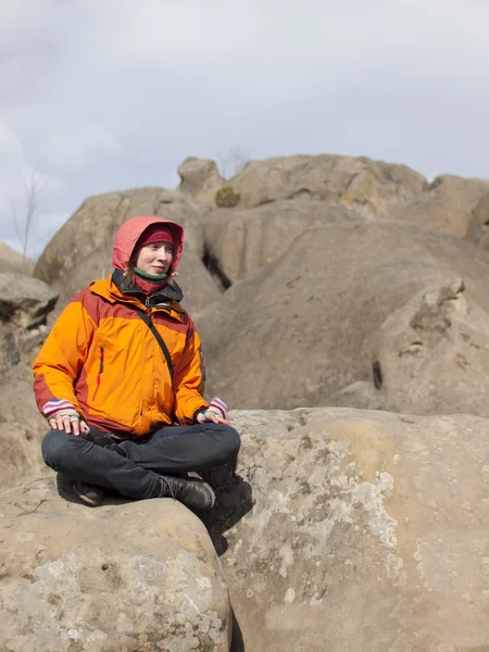 Meisje, zittend op een berg. — Stockfoto