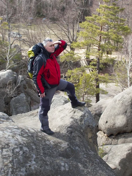 Een man staat op een berg en kijken in de verte. — Stockfoto