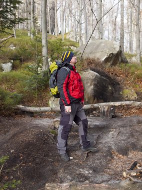 een man loopt door het bos.