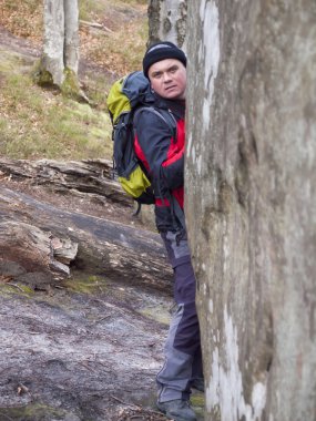 een man loopt door het bos.