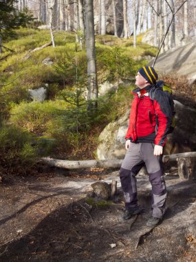 een man loopt door het bos.