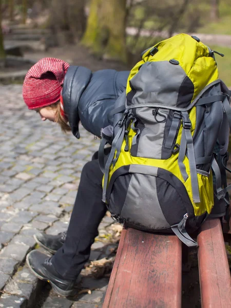 A young girl with a backpack resting in the Park. — Stock Photo, Image