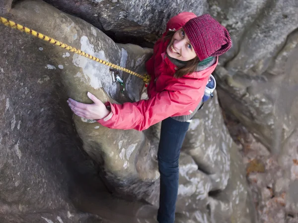 Girl climbing up a cliff. — Stock Photo, Image