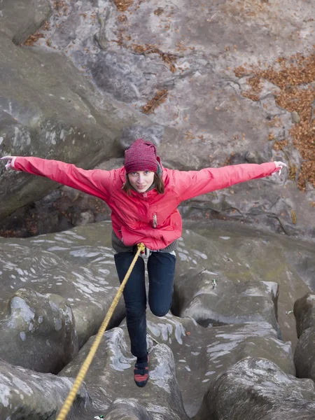 Girl climbing up a cliff. — Stock Photo, Image