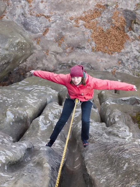 Girl climbing up a cliff. — Stock Photo, Image