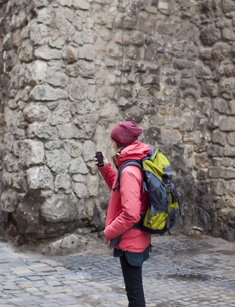 Telefonun fotoğraf çekmek bir sırt çantası ile genç bir kız. — Stok fotoğraf