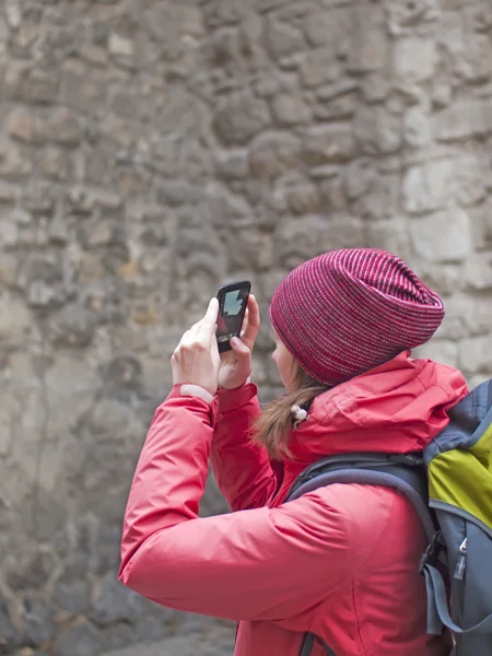 Ein junges Mädchen mit Rucksack und Handy. — Stockfoto