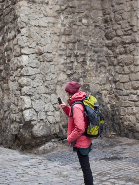 A young girl with a backpack and phone. — Stock Photo, Image