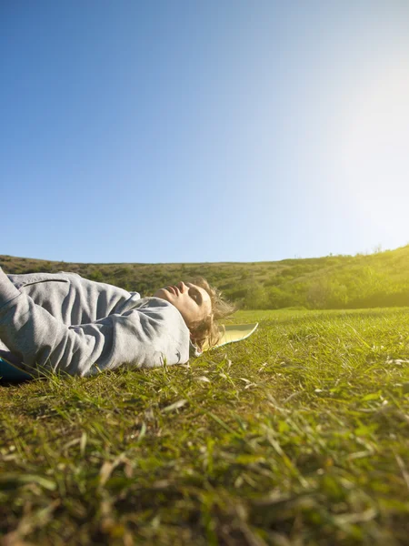 Jeune homme couché sur l'herbe verte . — Photo