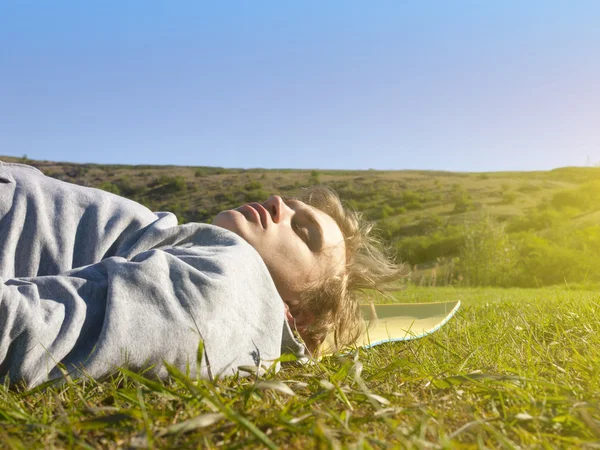 Ung man som ligger på det gröna gräset. — Stockfoto