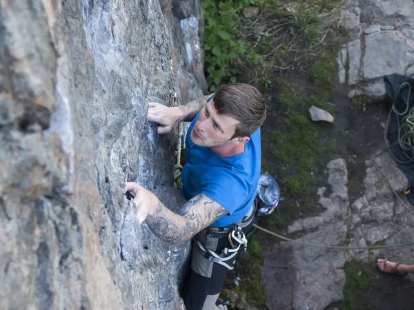 Hombre con tatuajes pared de escalada . — Foto de Stock