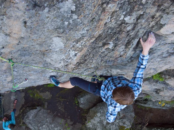 Beau homme en chemise à carreaux grimpe sur le rocher . — Photo