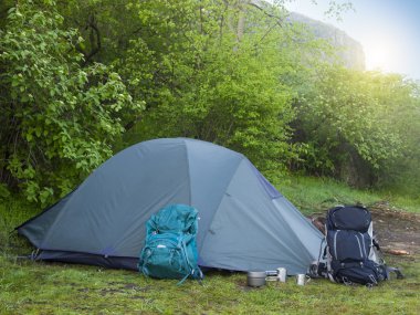 Büyük sırt çantaları ve açık havada duran t yanında yemek için mutfak eşyaları