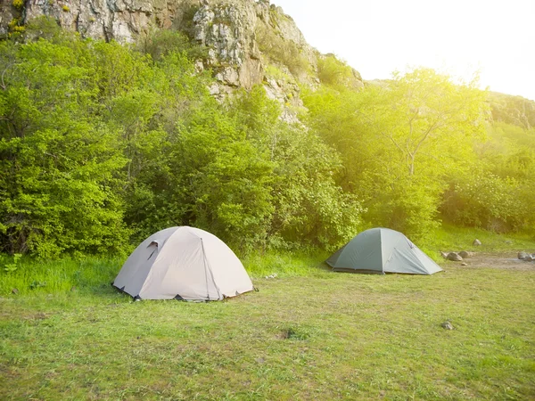 Due tende si trovano in una foresta con montagne sullo sfondo . — Foto Stock