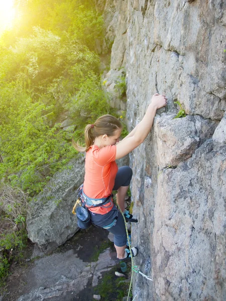 Dzielna dziewczyna wspina się na niebezpieczne skały. — Zdjęcie stockowe