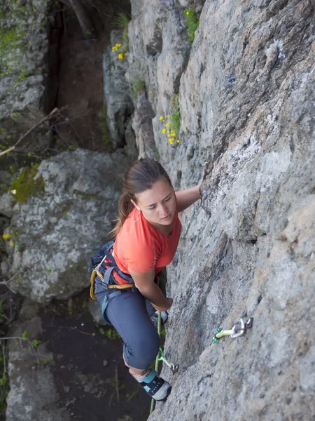 Brave girl climbs up on the dangerous rocks. — Stock Photo, Image