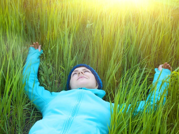 年轻的女孩躺在绿色的草丛中. — 图库照片