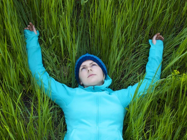 Ung flicka liggande i gröngräset. — Stockfoto