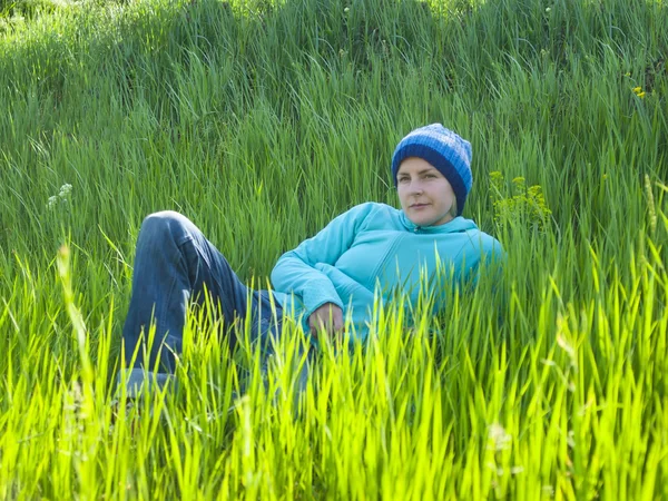 Ung flicka vilar i gräset. — Stockfoto