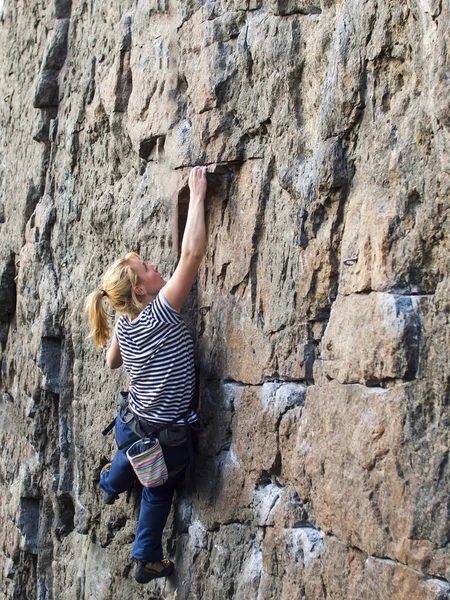 Молода жінка з мотузкою піднімається на скелю . — стокове фото