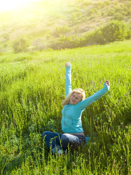 Retrato de menina bonita jovem em um campo gramado ao pôr do sol . — Fotografia de Stock