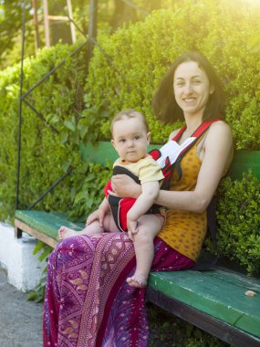 Küçük bir çocuk bir bebek tutan genç bir anne Doğu elbiseli