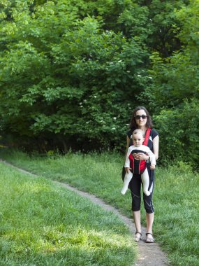 Küçük bir çocuk bir bebek tutan genç bir anne Doğu elbiseli