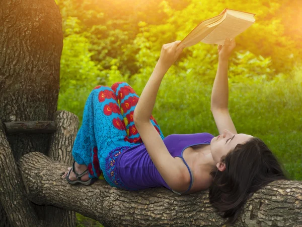 Flicka läsa en bok utomhus. — Stockfoto