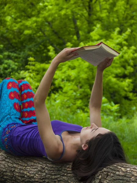 Flicka läsa en bok utomhus. — Stockfoto