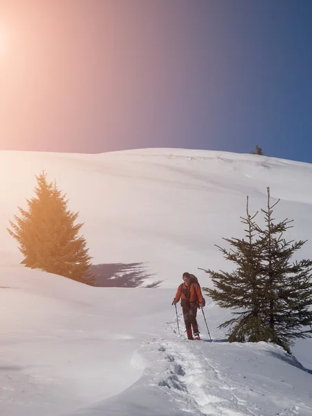 Een man in sneeuwschoenen is de sneeuw. — Stockfoto