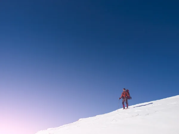 Um homem de sapatos de neve está nas montanhas. . — Fotografia de Stock