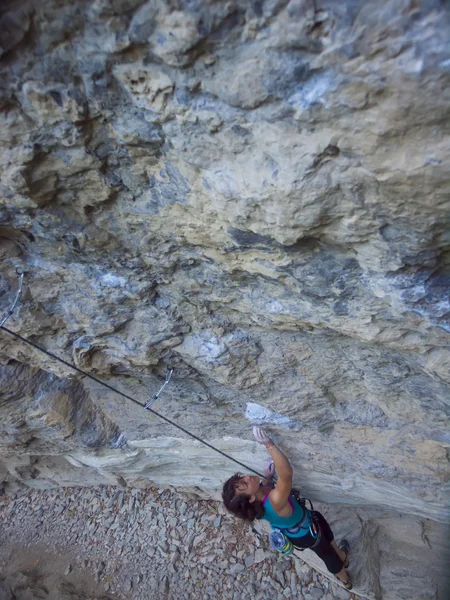 ロープを持つ若い女性が岩の上に登る. — ストック写真