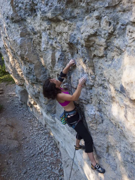 ロープを持つ若い女性が岩の上に登る. — ストック写真
