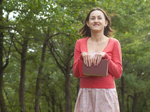 Una joven sosteniendo un libro . — Foto de Stock