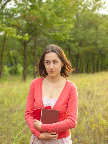 Une jeune fille tenant un livre . — Photo