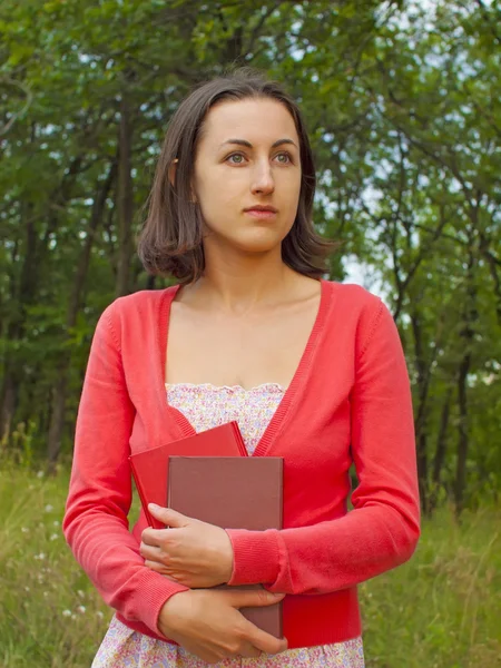 Una joven sosteniendo un libro . — Foto de Stock