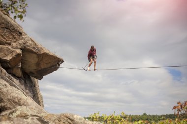 Bir insan slackline yürüyor.