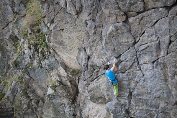 Jonge vrouw met touw klimt op de rots. — Stockfoto
