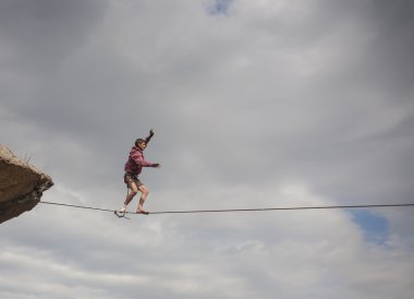 Bir insan slackline yürüyor.