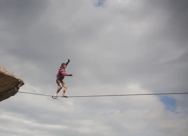 Un uomo cammina lungo slackline . — Foto Stock