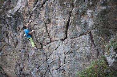Kız kayaya tırmanıyor.