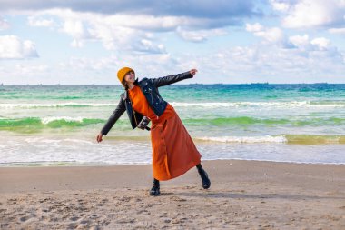 Kameralı şık bir kadın güneşli bir günde plaja gitmekten hoşlanır. Yaşam tarzı, seyahat, turizm, doğa, aktif yaşam.