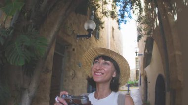 Şehirde bir kız dolaşıyor ve bazı işaretler taşıyor. Bir kız seyahat eder ve blogu için içerik çeker. Kameralı bir turist..